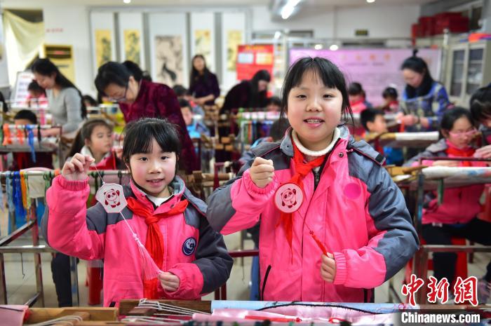 圖為小學(xué)生展示繡制好的2022年北京冬奧會(huì)吉祥物“冰墩墩”形象?！∮髟屏?攝