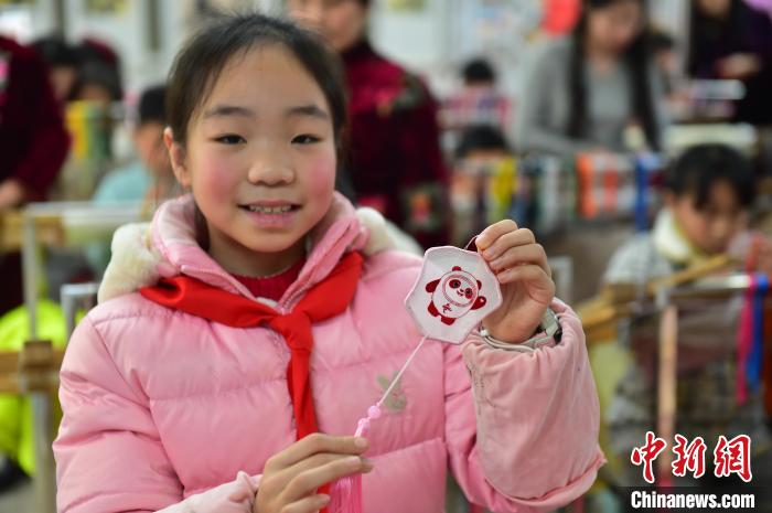 圖為一名小學(xué)生繡制的2022年北京冬奧會(huì)吉祥物“冰墩墩”形象。　喻云亮 攝