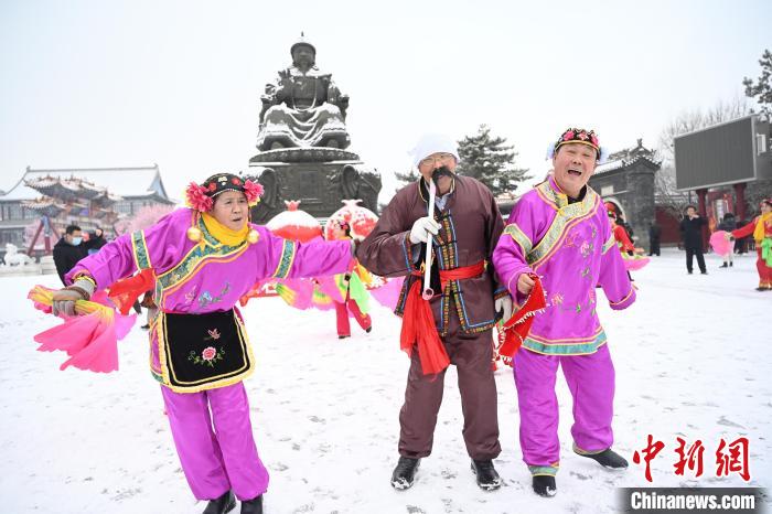 2月13日，秧歌隊在呼和浩特市大召廣場雪中起舞?！⑽娜A 攝