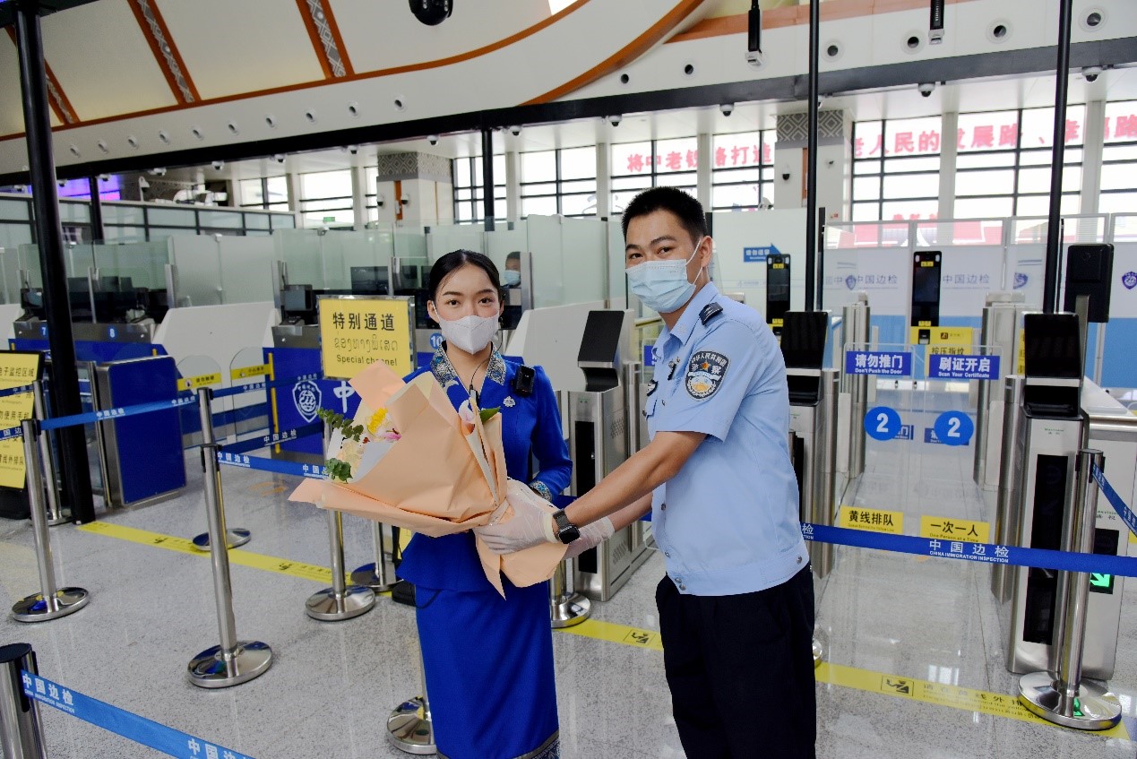 磨憨出入境邊防檢查站民警為中老鐵路第100萬(wàn)名出入境旅客，D888次國(guó)際旅客列車?yán)蠐爰藙?wù)員森達(dá)拉·妮緹婭（Sengdala Nitiya），送上鮮花。黃遠(yuǎn)飛 攝