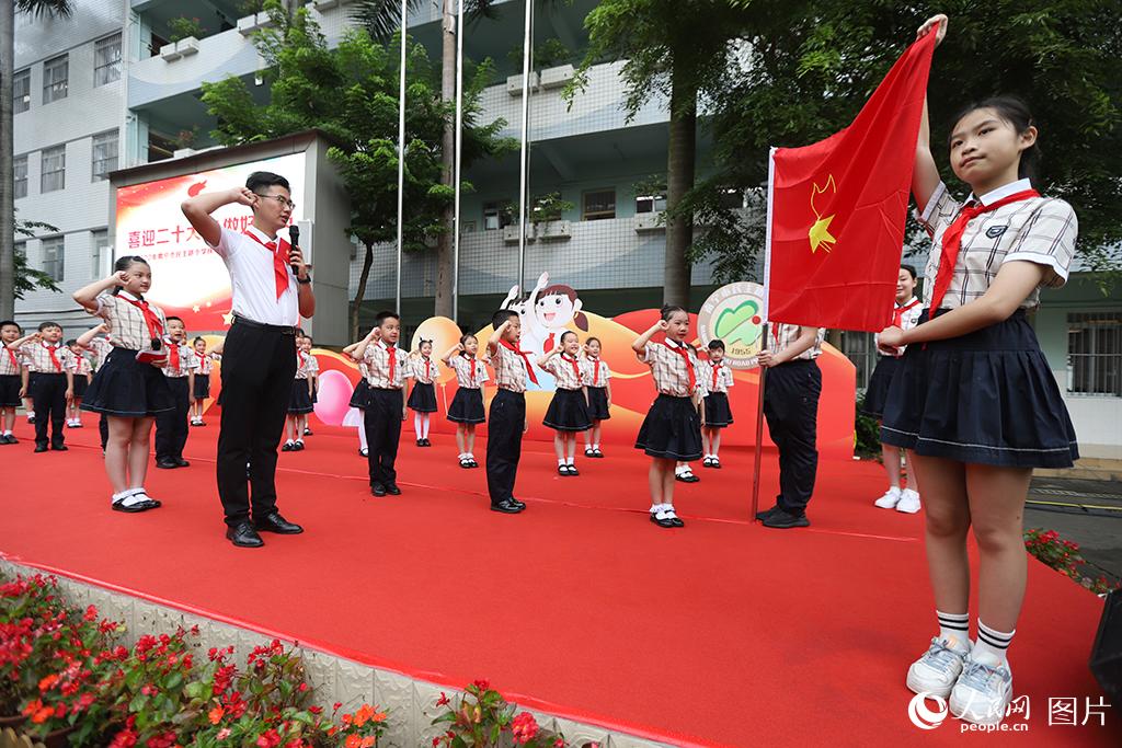 5月31日，在廣西壯族自治區(qū)南寧市民主路小學(xué)，學(xué)校大隊輔導(dǎo)員帶領(lǐng)少先隊員呼號。人民網(wǎng)記者 嚴(yán)立政攝