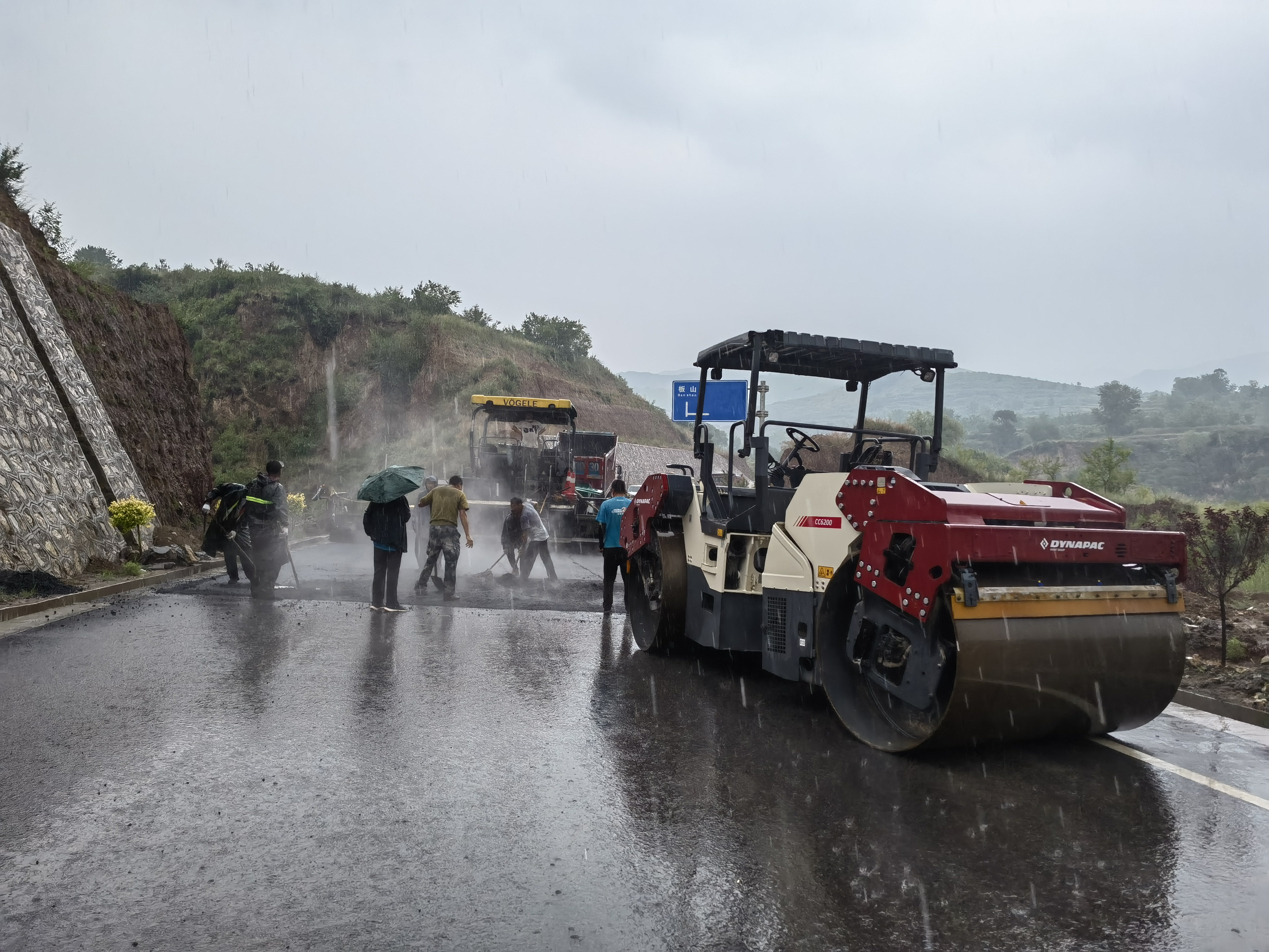 路橋工人在大雨中搶修道路。李華英 攝