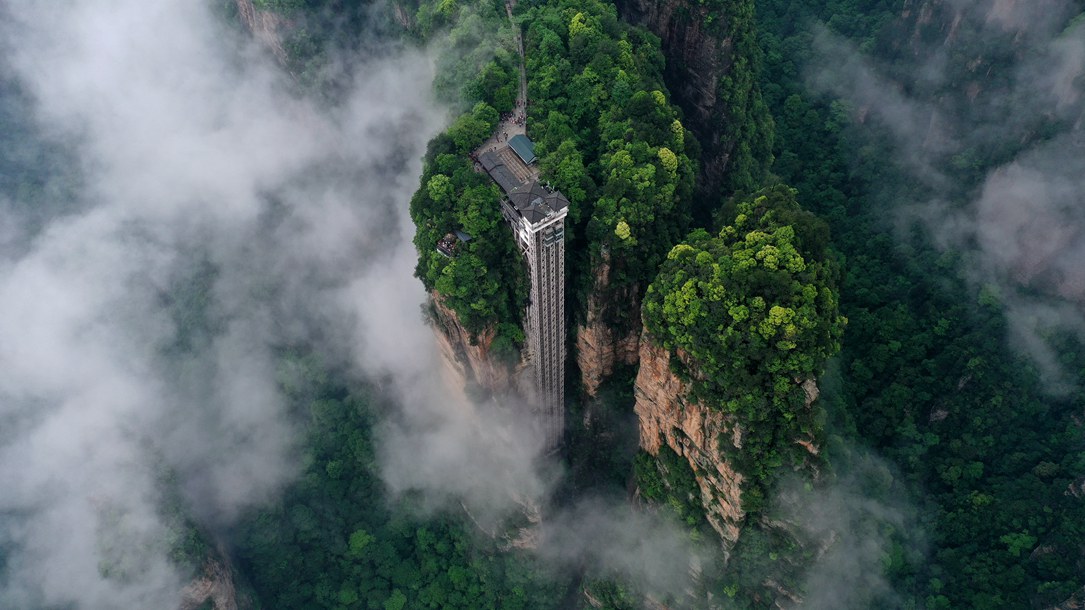 位于張家界武陵源景區(qū)的百龍?zhí)焯蓁偳对谠旗F繚繞的峰林間，雄偉壯觀。吳勇兵攝