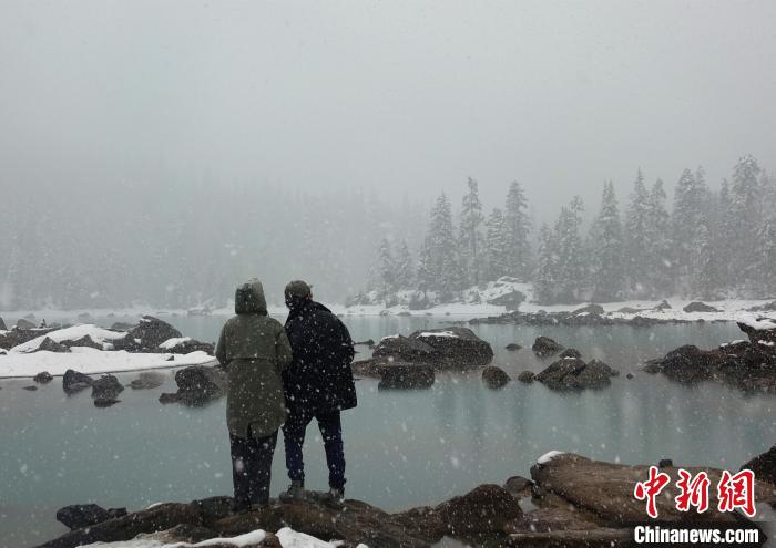 游客欣賞雪中然烏湖。　冉文娟 攝