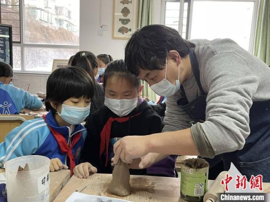 圖為西寧市勞動路小學(xué)教師賈煜與學(xué)生一起制作陶藝?！≈苋鸪阶?攝