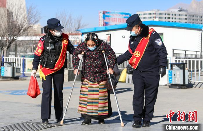 圖為拉薩鐵路公安民警幫助老人進站乘車。　胡安鵬 攝