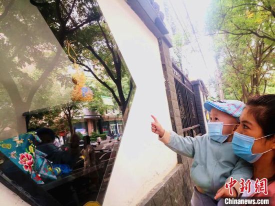 圖為蘭州市民在街頭觀賞刺繡和刻葫蘆的非遺展示。(資料圖) 史靜靜 攝