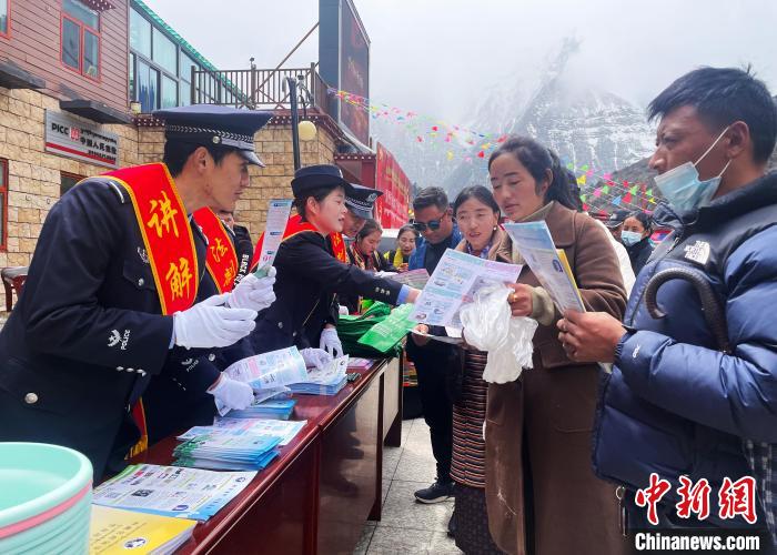 圖為山南玉麥邊境派出所民警為轄區(qū)群眾發(fā)放法律知識(shí)宣傳單?！＄婗?　攝