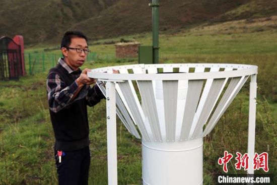 圖為班瑪縣氣象局工作人員在維護藏雪茶基地氣候站。青海省氣象局供圖