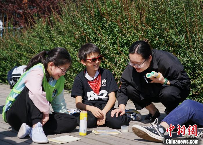 圖為小朋友在青海西寧湟水國家濕地公園內(nèi)認識植物并進行繪畫?！●R銘言 攝