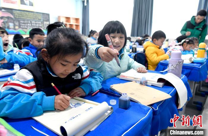 3月14日，西藏拉薩市第一小學(xué)一年級(jí)六班學(xué)生白瑪朗珍(圖左)在藏語文課上書寫藏文?！±盍?攝