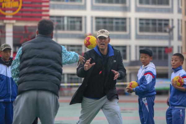 在高原上教孩子們打手球，“慢慢兒來(lái)，甭著急！”