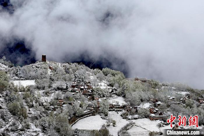 雪后的藏寨和碉樓構(gòu)成美麗的雪景?！〗党鯘衫?攝