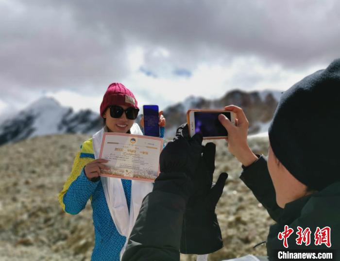 圖為5日，登頂洛堆峰的登山者獲得西藏自治區(qū)登山協(xié)會頒發(fā)的登頂證明?！垈?攝