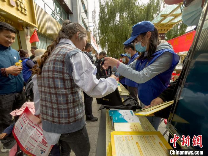 圖為志愿者為市民發(fā)放網(wǎng)絡(luò)安全宣傳手冊。　謝牧 攝