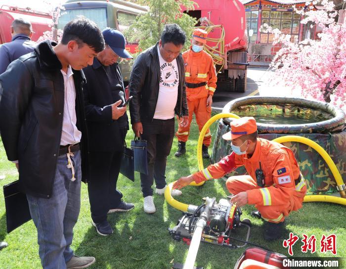 圖為森林消防員為護林員講解滅火裝備的使用方法?！〔际猩窒乐ш?供圖