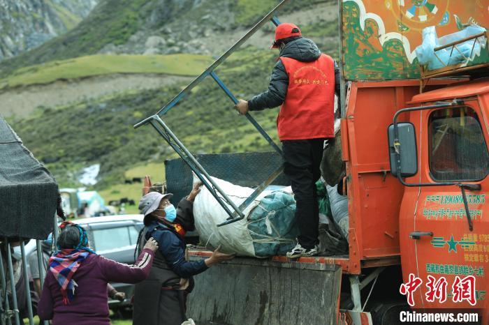 圖為工作人員幫助牧民們卸家具?！÷蹇?攝