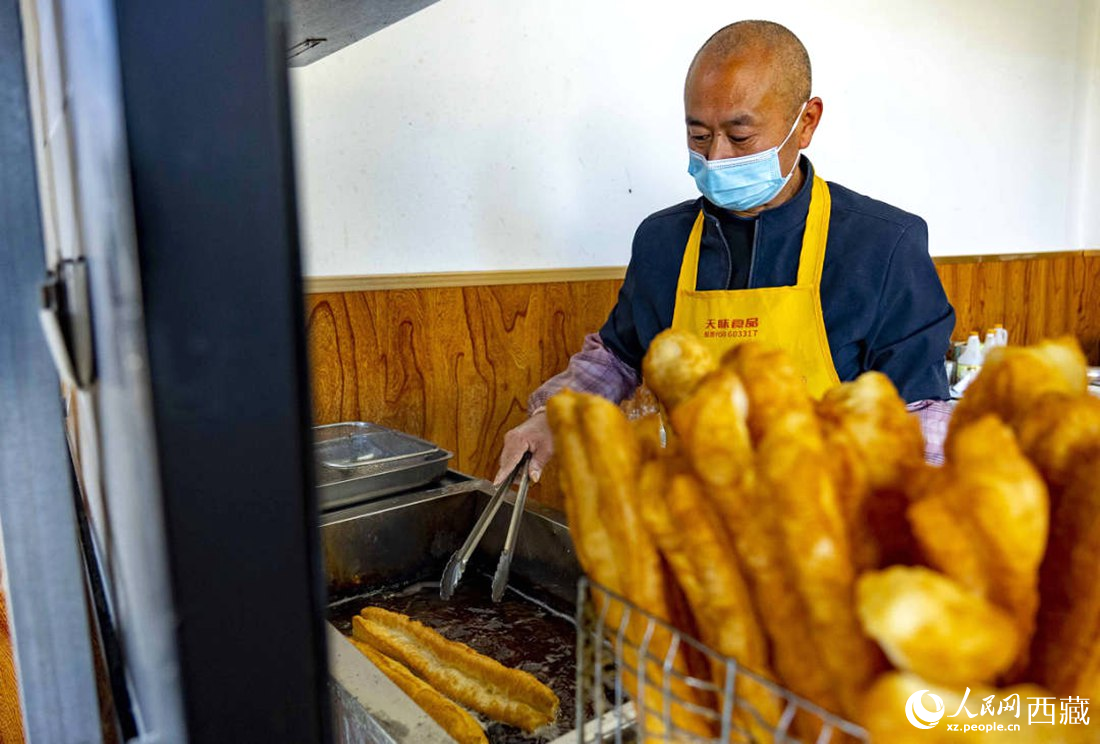 早餐店老板正在炸油條。人民網(wǎng) 次仁羅布攝