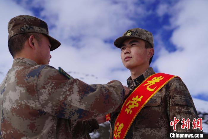 排長王朝偉(圖左)給退伍老兵佩戴大紅花?！∥鞑厣侥宪姺謪^(qū)某團供圖