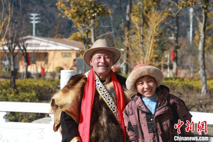 圖為林芝市巴宜區(qū)布久鄉(xiāng)仲果村村民桑杰與孫子一起參加藏歷新年活動(dòng)?！埩?攝