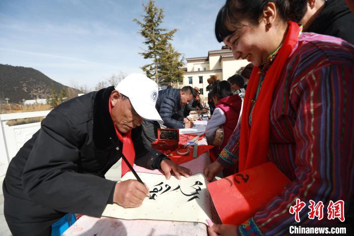 圖為林芝市文聯(lián)書(shū)法家協(xié)會(huì)會(huì)員向民眾贈(zèng)送藏文書(shū)法作品?！埩?攝